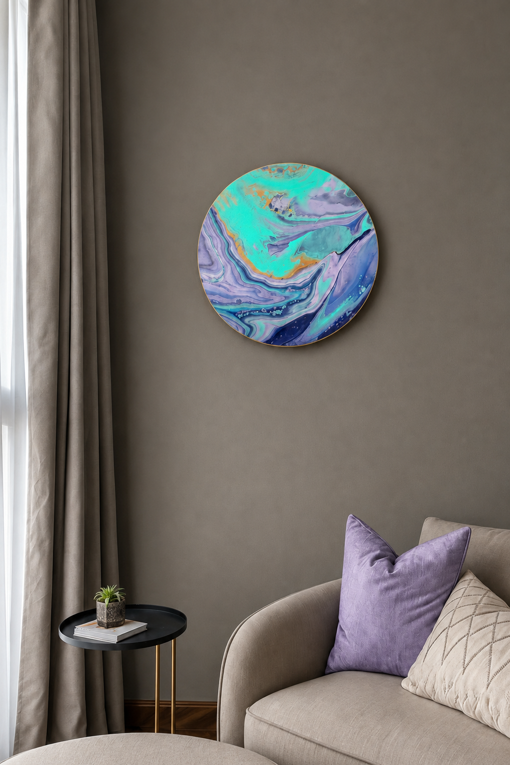 A round abstract wall art piece with swirling turquoise, purple, and blue marbled patterns hanging on a taupe-gray wall above a beige sofa with purple and cream pillows.